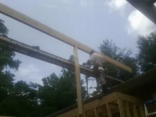 Carpenter setting a ridge beam over a new addition frame — Ice Dam Removal by Roofing Brothers in Foxboro