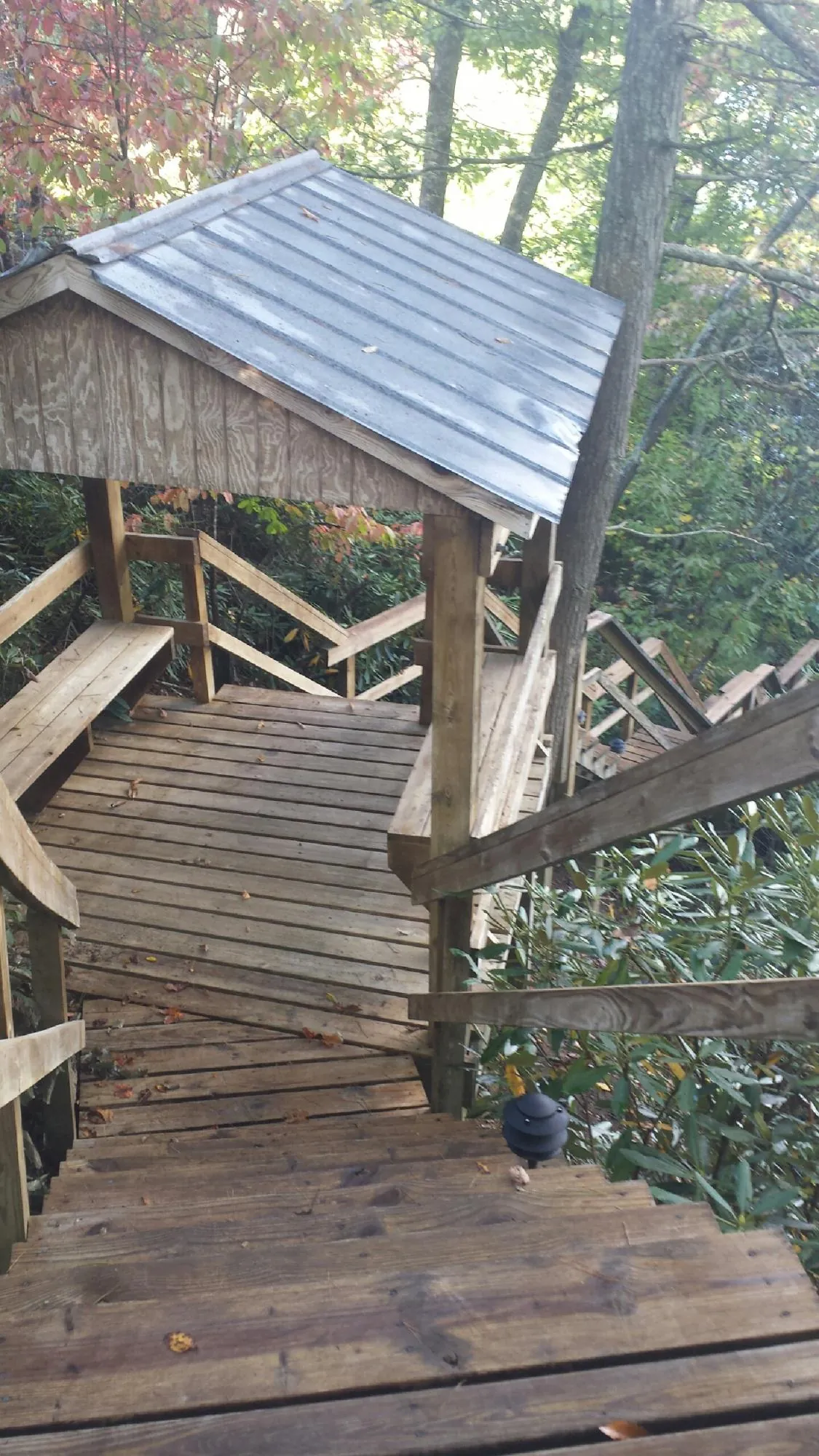 Metal roofed shelter over wooden steps on a wooded walkway — Skylight Repair & Installation work by our crew in Foxboro