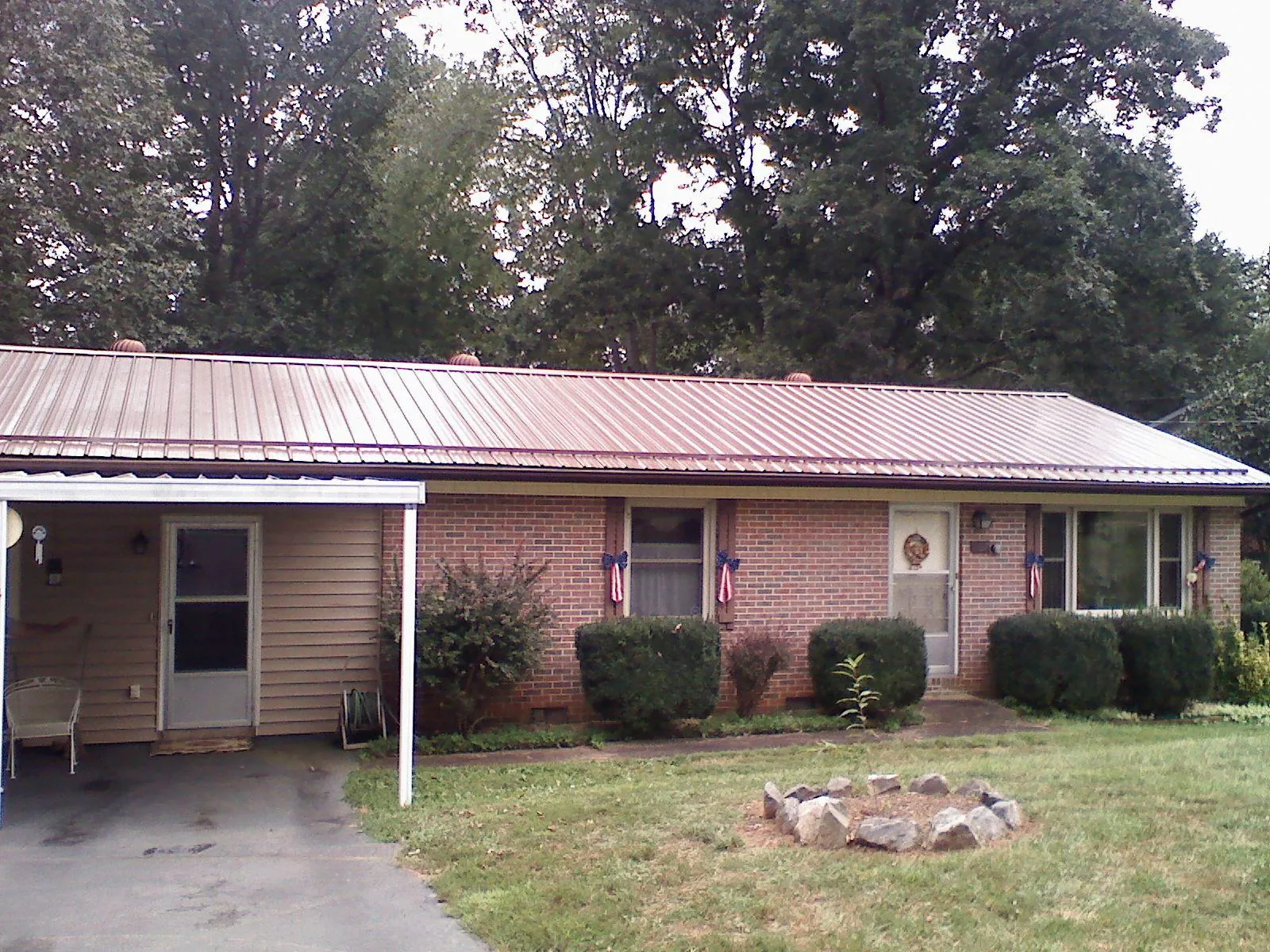 Bronze metal roof and carport on a brick ranch home — Roof Repair work by our crew in Foxboro